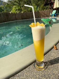 a drink sitting on a table next to a swimming pool at Elephant garden2 in Trat