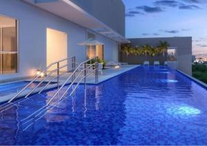 a large swimming pool with blue water in a building at Metropolitan Sidney in Goiânia
