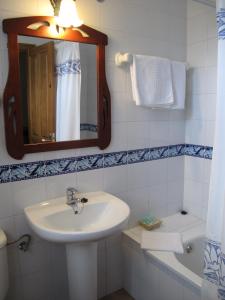 La salle de bains est pourvue d'un lavabo, d'un miroir et d'une baignoire. dans l'établissement Hotel Casa Anita, à San Juan de Plan