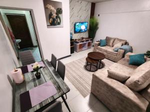 a living room with a couch and a table at Meg Cozy Homes Executive 1Bedroom and 2Bedroom Apartments Near Rupa Mall The Noble Hotel & Poa Place Resort in Eldoret