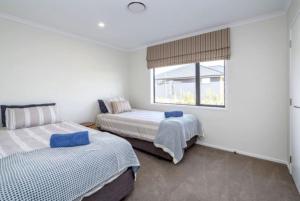 a bedroom with two beds and a window at Arthurs Vineyard - Sleeps 10 in Martinborough