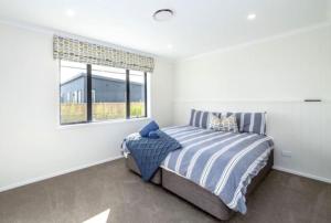 a bedroom with a bed and a window at Arthurs Vineyard - Sleeps 10 in Martinborough