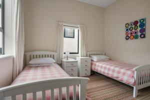 a bedroom with two beds and a window at Claras Togs and Towels in Waihi Beach