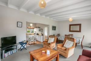 a living room with a couch and a tv at Claras Togs and Towels in Waihi Beach