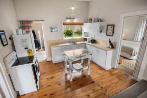 a kitchen with white appliances and a wooden floor at Claras Togs and Towels in Waihi Beach