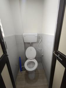 a small bathroom with a toilet in a stall at Desai Home Stay in Kolhapur