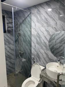 a bathroom with a shower and a toilet and a sink at Thien Khanh Hotel for rent in Danang
