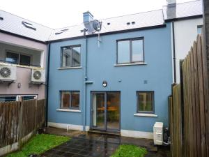 a blue house with a fence in front of it at Dingle Doorstep - Town Centre in Dingle