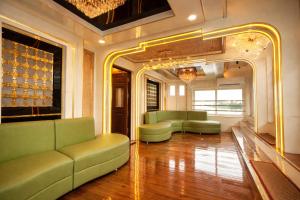 a living room with green couches and a mirror at Best Homestay in Alappuzha 4 BR- LAYANILA in Alleppey