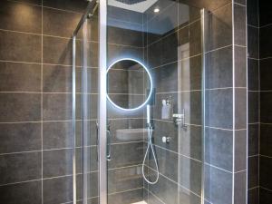 a bathroom with a shower with a round mirror at Dingle Doorstep - Town Centre in Dingle +25 photos