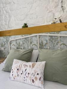 a bed with two pillows and a white headboard at La Casuca ONE De Lebeña in Lebena