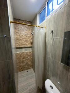 a bathroom with a shower with a toilet and a window at HOSTAL CARACOLI - HUECO in Valledupar