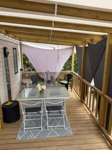 a patio with a table and chairs on a deck at Mobile Home 198 in Saint-Denis-dʼOléron