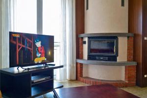 a living room with a television and a fireplace at Casa Mariarosa in Maccagno Inferiore