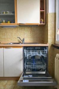 a dishwasher in a kitchen with its door open at Casa Mariarosa in Maccagno Inferiore +9 photos