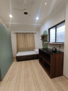 a room with a bed and a desk and a window at Desai Home Stay in Kolhapur