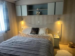 a bedroom with a large bed with a blue blanket at Gorsehill 44 in Lytchett Minster