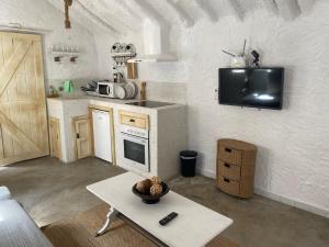 a kitchen with a table and a tv on the wall at Estudio Aryas nest 2 in Mijas