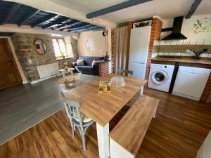 a kitchen and living room with a wooden table at La Casuca ONE De Lebeña in Lebena +25 photos