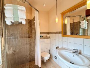 a bathroom with a sink and a toilet and a shower at Gasthaus Beinker in Ostercappeln +67 photos