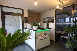 eine Küche mit einem Kühlschrank und einer Theke mit Pflanzen in der Unterkunft Hotel7Continents in Neutraubling