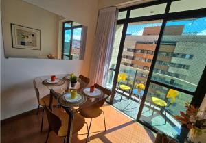 a dining room with a table and a large window at Volpi Residence Savassi - VIP - Sinta-se em casa in Belo Horizonte