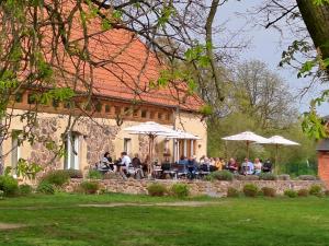 a group of people sitting at a table with umbrellas at Unterkunft Mohr - Gemütlichkeit im Souterrain in Schmerwitz