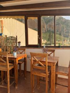 a dining room with wooden tables and chairs and windows at Hellas Makari B&B in Macari