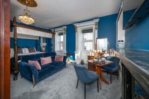 a blue living room with a couch and a bed at Abbey View Townhouse in Youghal