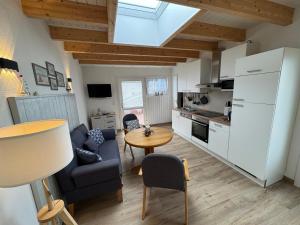 a kitchen and living room with a table and chairs at Hotel Zum Hanseaten in Borkum