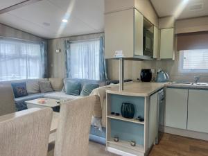 a kitchen and a living room with a couch and a table at Gorsehill 44 in Lytchett Minster