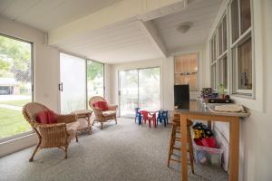 a living room with chairs and a table and windows at Lake Views & Fire Pit in South Haven