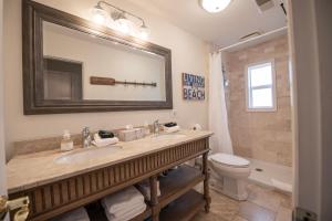 a bathroom with a sink and a toilet and a mirror at Lake Views & Fire Pit in South Haven +29 photos