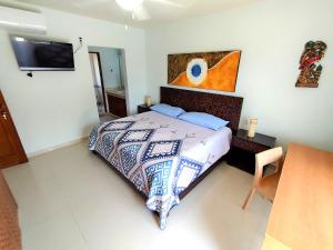 a bedroom with a bed and a tv on the wall at Beautiful apartment, prime location, beach 2 minutes away in Puerto Aventuras
