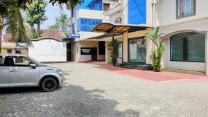 a car parked in front of a building at Thomson Kylas Rooms in Ettumānūr