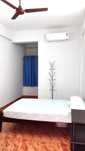 a bedroom with a bed with a ceiling fan at Thomson Kylas Rooms in Ettumānūr +2 photos