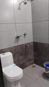 a bathroom with a toilet and a shower at Thomson Kylas Rooms in Ettumānūr