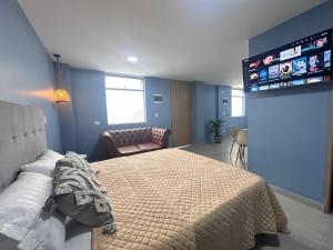 a bedroom with a bed and a flat screen tv at Amaranto Suites in Medellín