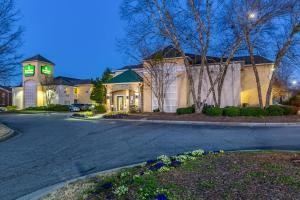 a house with a green light on a driveway at HomeTowne Studios by Red Roof Atlanta - Peachtree Corners in Norcross