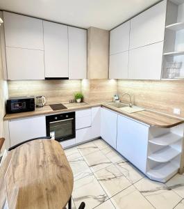 a kitchen with white cabinets and a wooden table at Троїцька площа 3 Квартира Самий Центр Окремий Вхід in Dnipro +10 photos