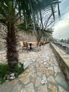 a patio with a table and chairs and a palm tree at Hotel Yjet in Pogradec