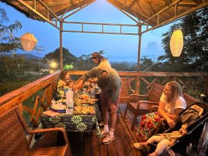 a group of people sitting around a table on a deck at Arbaminch eco campsite and lodge in Ārba Minchʼ