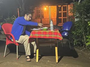 a man sitting at a table with a plate of food at Arbaminch eco campsite and lodge in Ārba Minchʼ +7 photos