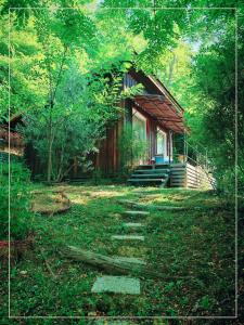a small cabin in the middle of a forest at La Pause En Soi - Cabanes climatisées avec Jaccuzi privatif en option in Ponlat-Taillebourg