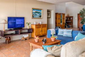 a living room with a blue couch and a tv at Boardwalk in Britannia Bay