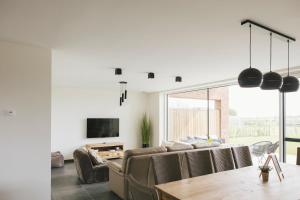 a living room with a couch and a table at Vakantiewoning 't Veld in Ledegem