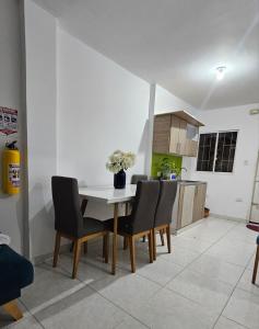 a kitchen with a white table and chairs and a kitchen with a kitchen at HOSTAL CARACOLI - HUECO in Valledupar