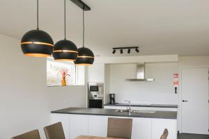 a kitchen with black and white cabinets and a sink at Vakantiewoning 't Veld in Ledegem