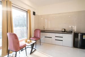 a kitchen with two chairs and a table and a window at 46 Elite Enclave in Nashik