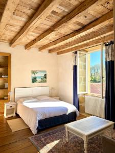 a bedroom with a bed and a large window at "La Maison de Villars" au coeur de la nature in Pressac